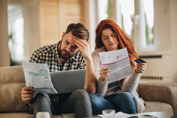 Two people looking at bills, slightly worried